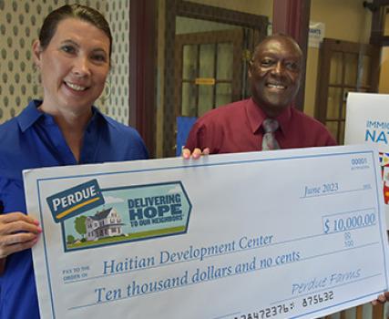 Kim Nechay, executive director of the Perdue Foundation, presents a $10,000 grant to the Rev. Roosevelt Toussaint.