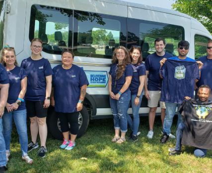 Perdue associates stand in front of a van that was funded through a $50,000 Perdue Foundation grant for the International Center of Kentucky. 