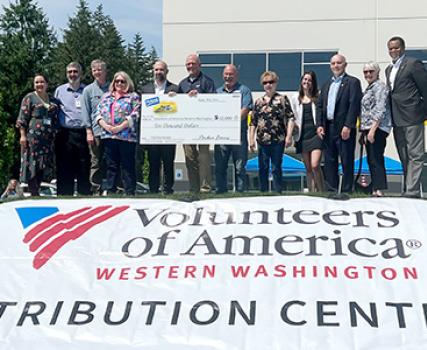 Scott Taylor, director of operation for Perdue Farms, presents a $10,000 grant to Brian Smith, president and CEO of Volunteers of America Western Washington.