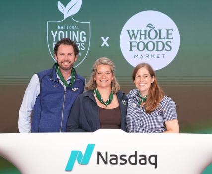 Three people standing at Nasdaq podium with Whole Foods and company logos behind them.
