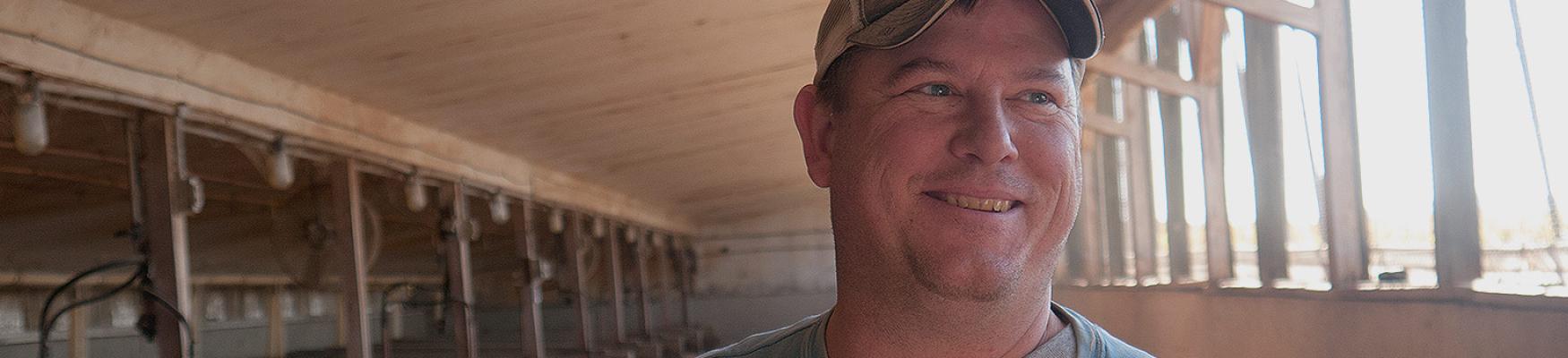 Man wearing cap in indoor setting with shelving in background