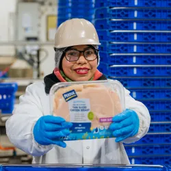 Perdue factory worker holding a pack of chicken