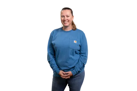 Person wearing blue long-sleeve shirt standing against neutral background.