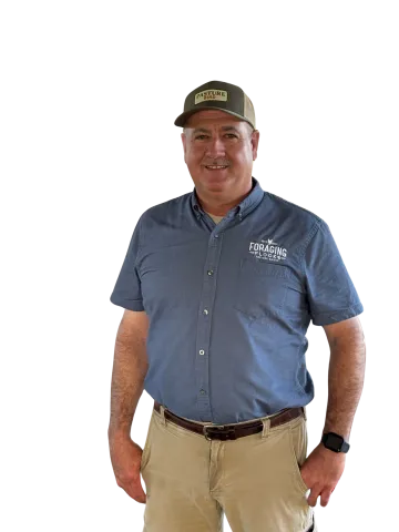 Man wearing blue short-sleeve work shirt with company logo and khaki pants against white background.