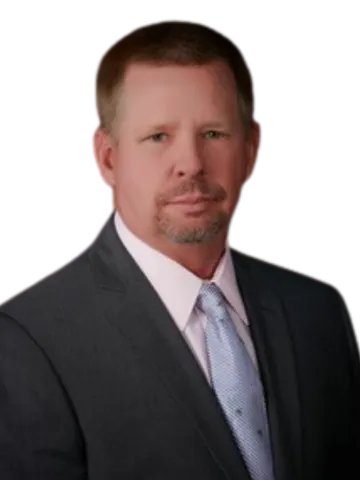 Man in dark blazer and light blue shirt against white background