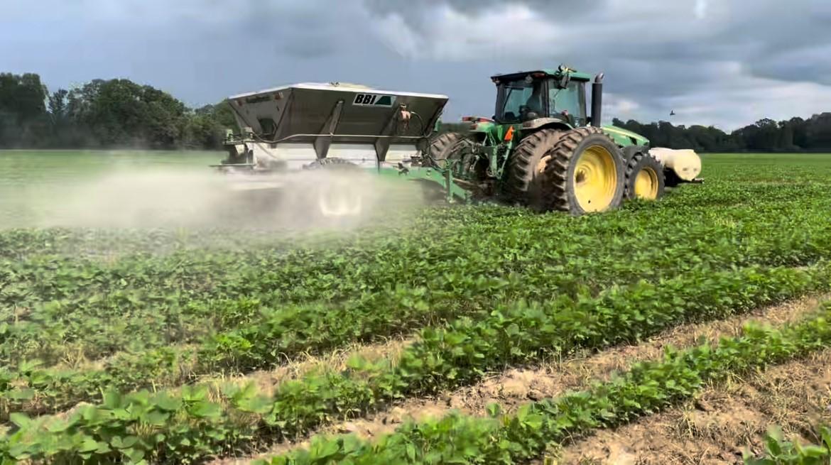 Tractor spraying crops in agricultural field