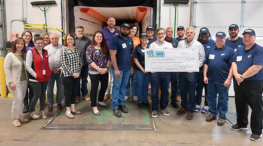 Perdue Foundation grant to Michale McKee, CEO of the Blue Ridge Area Food Bank, to support the food bank&rsquo;s Good Food School Market child nutrition program as Perdue volunteers and food bank staff look on.