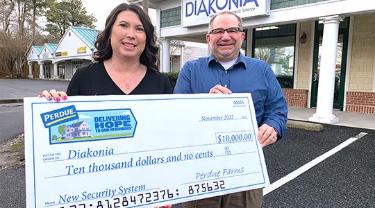 Kim Nechay, executive director of the Franklin P. and Arthur W. Perdue Foundation, presents a $10,000 check to Ken Argot, executive director of Diakonia Inc., for a new security system.