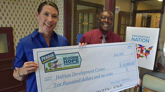 Kim Nechay, executive director of the Perdue Foundation, presents a $10,000 grant to the Rev. Roosevelt Toussaint.
