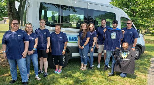 Perdue associates stand in front of a van that was funded through a $50,000 Perdue Foundation grant for the International Center of Kentucky. 