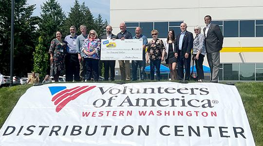 Scott Taylor, director of operation for Perdue Farms, presents a $10,000 grant to Brian Smith, president and CEO of Volunteers of America Western Washington.