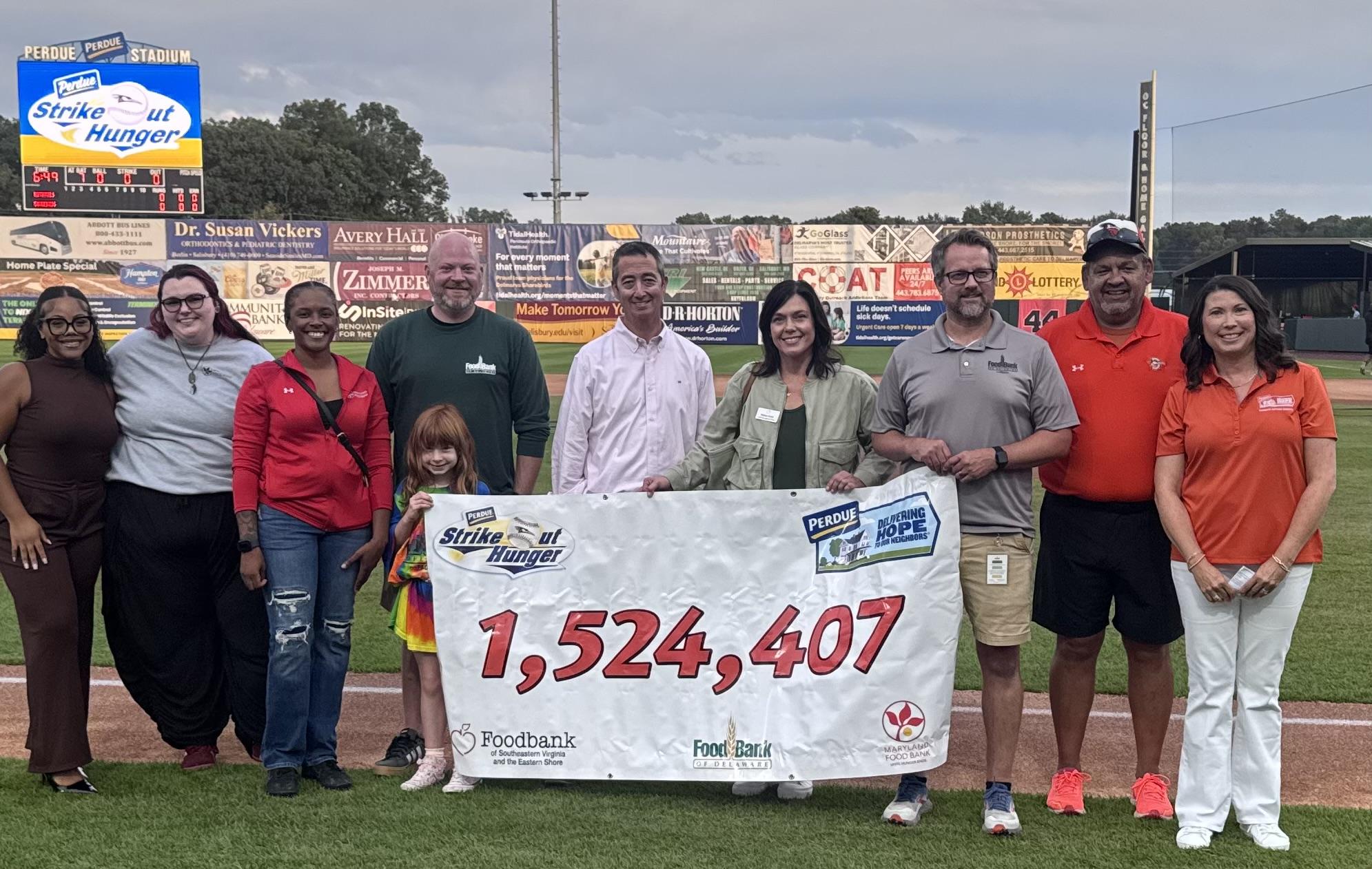 Group of people holding large check for 1,524,407 at outdoor event